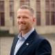 Porträtfoto - Adam Balten vor dem historischen Rathaus in Wesel.